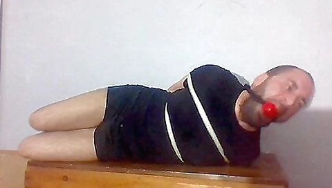 Naked guy is being fucked by a strap on bondage doll